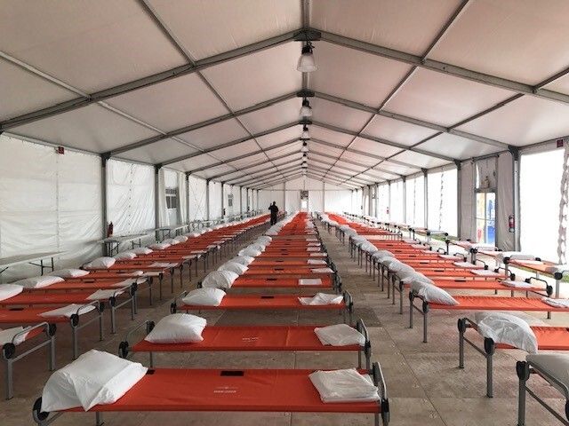 Rows of orange beds in a large tent-like structure